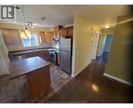 A kitchen with wooden cabinets and a refrigerator.