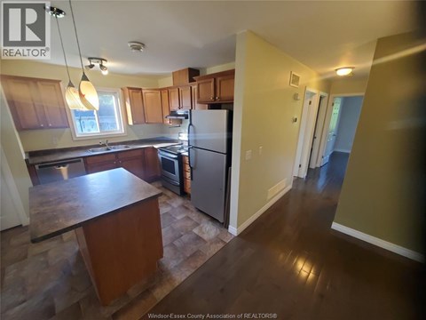 A kitchen with wooden cabinets and a refrigerator.