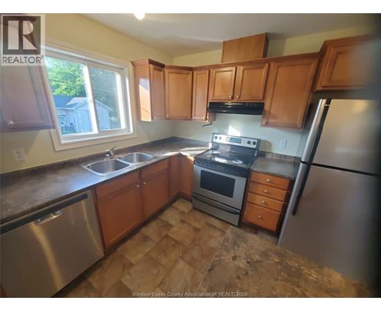 A kitchen with wooden cabinets and stainless steel appliances.