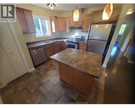 A kitchen with wooden cabinets and a granite countertop.