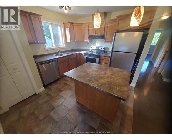 A kitchen with wooden cabinets and a granite countertop.