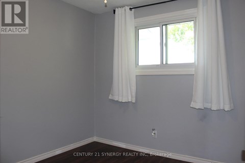 A room with a window and curtains, with a logo on the wall.