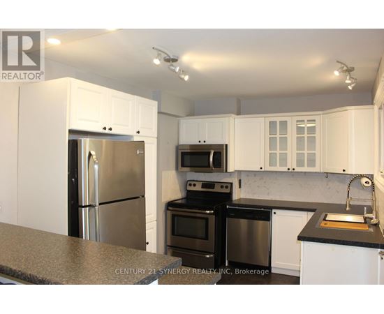 A kitchen with white cabinets and black appliances.
