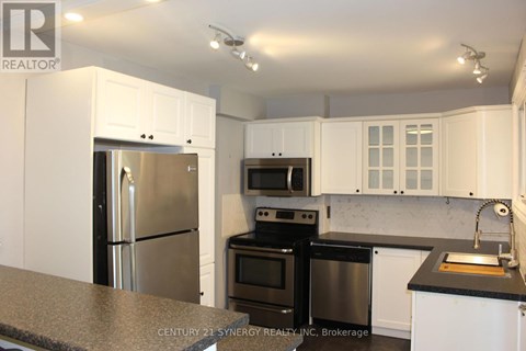 A kitchen with white cabinets and black appliances.