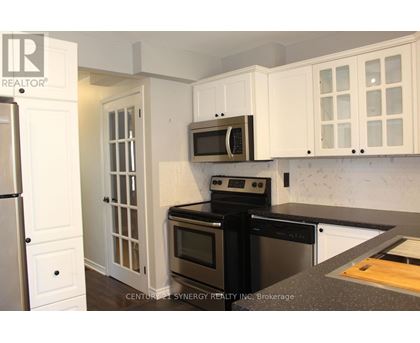 A kitchen with white cabinets and black appliances.