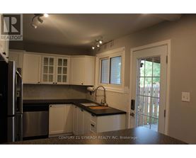 A kitchen with white cabinets and a black countertop.