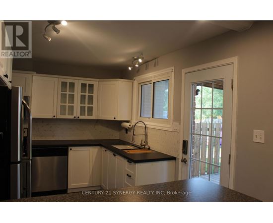 A kitchen with white cabinets and a black countertop.
