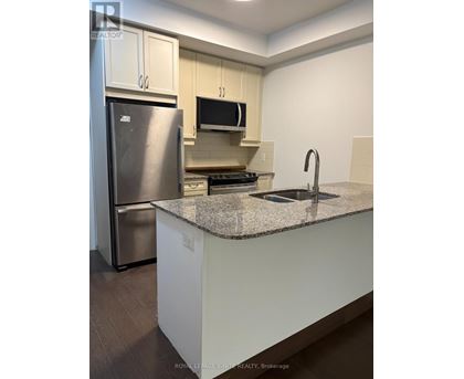 A kitchen with a granite countertop and stainless steel appliances.