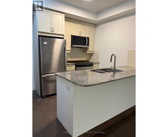 A kitchen with a granite countertop and stainless steel appliances.