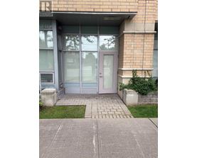 The image shows a glass door entrance to a building with a sign that reads "REALTOR".