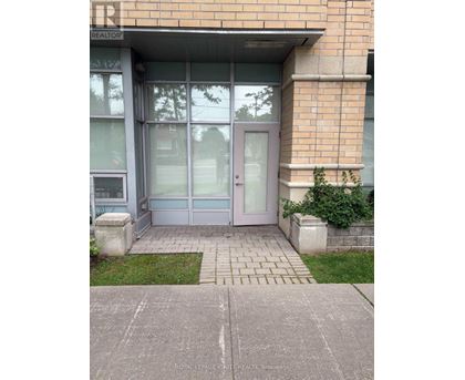 The image shows a glass door entrance to a building with a sign that reads "REALTOR".
