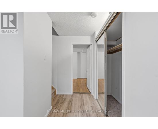 A brokerage sign is on the wall of a white room.