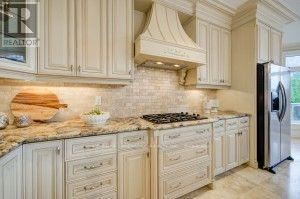 A kitchen with white cabinets and a marble countertop.