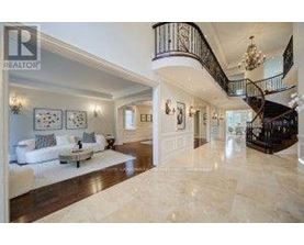 A spacious living room with a marble floor and a spiral staircase.