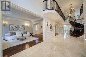 A spacious living room with a marble floor and a spiral staircase.