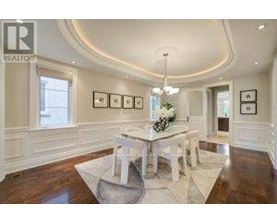 A dining room with a white table and chairs.