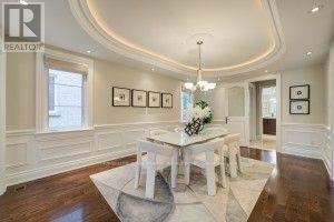 A dining room with a white table and chairs.