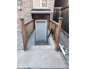 A small white door is in a concrete covered area.