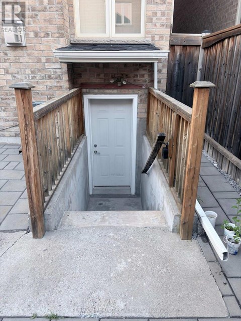 A small white door is in a concrete covered area.