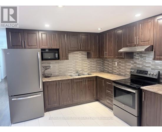 A kitchen with wooden cabinets and a stone backsplash.