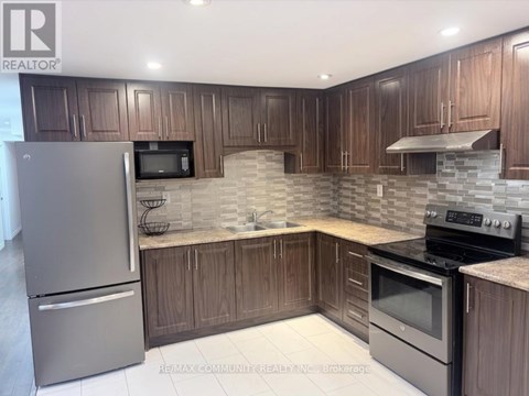 A kitchen with wooden cabinets and a stone backsplash.