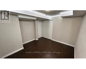 A spacious room with a sliding door and wooden flooring.