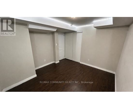 A spacious room with a sliding door and wooden flooring.