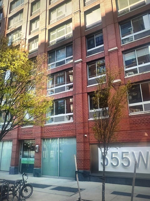 A tall red brick building with the number 55 on the front.