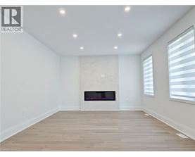 A spacious room with a fireplace and wooden flooring.