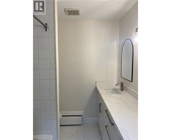 A white bathroom with a sink and mirror.