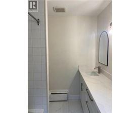 A white bathroom with a sink and mirror.