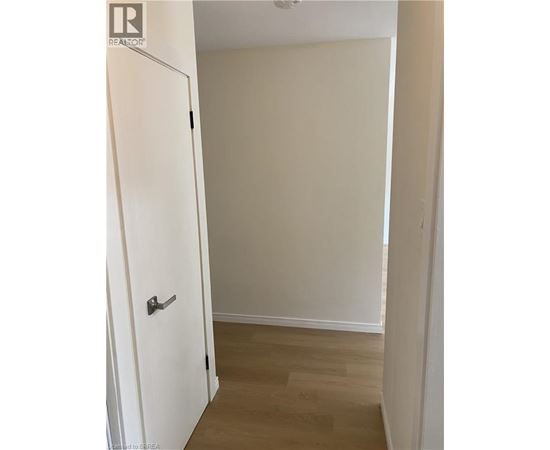 A white door is in a room with a wooden floor.