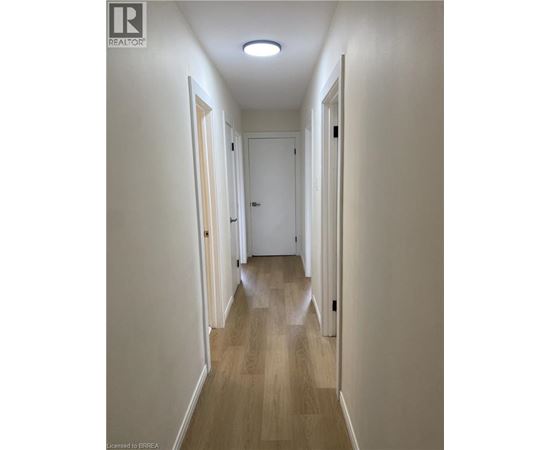 A long hallway with doors on both sides and a light on the ceiling.