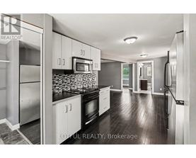 A modern kitchen with stainless steel appliances and white cabinets.