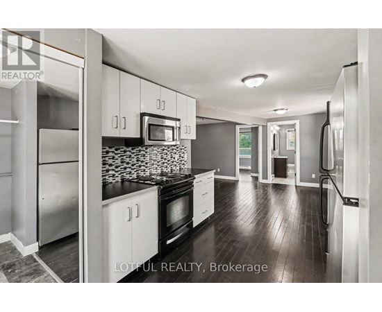 A modern kitchen with stainless steel appliances and white cabinets.