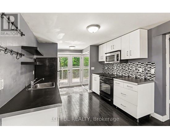 A modern kitchen with a black countertop and white cabinets.