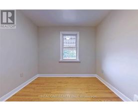 A room with a window and wooden flooring.