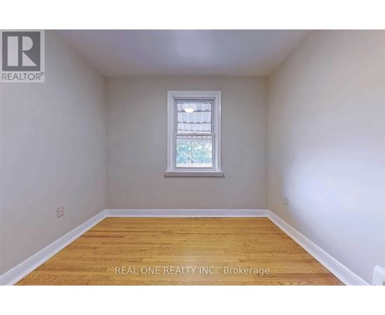 A room with a window and wooden flooring.