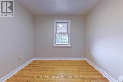 A room with a window and wooden flooring.