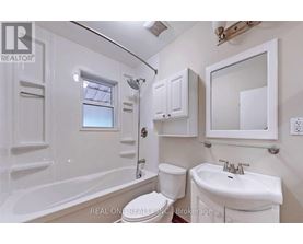 A white bathroom with a tub, toilet, and sink.