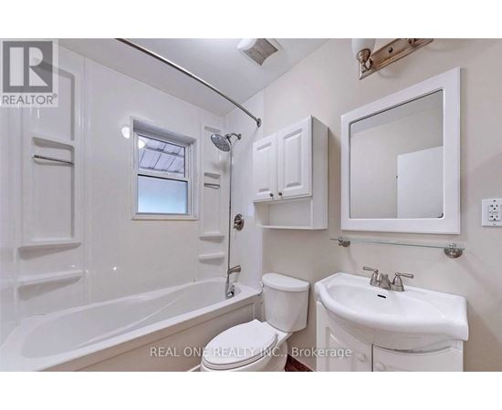 A white bathroom with a tub, toilet, and sink.