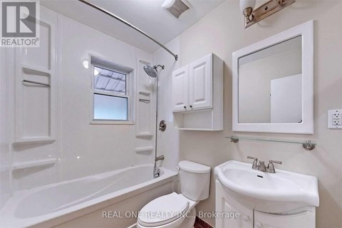A white bathroom with a tub, toilet, and sink.