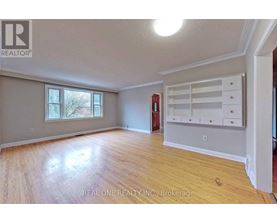 A room with wooden flooring and a large window.