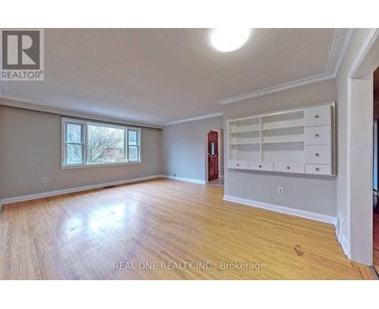 A room with wooden flooring and a large window.