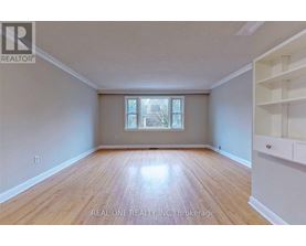 A room with wooden flooring and a window with white blinds.