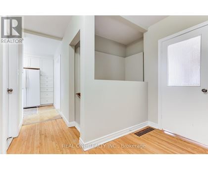 A room with wooden flooring and a window with white blinds.