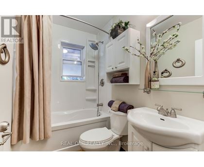 A kitchen with white cabinets and a window above the sink.