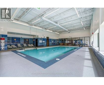 A large indoor swimming pool with a blue tiled floor.