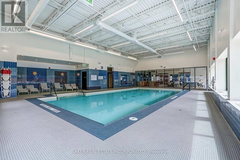 A large indoor swimming pool with a blue tiled floor.
