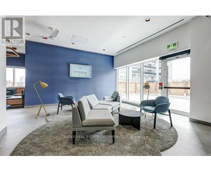 A living room with a grey rug and a white sofa.